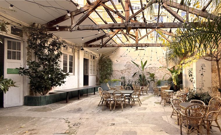 View of the Svelte Summit venue in Barcelona: a courtyard with concrete floor, tablees with chairs and light garlands.