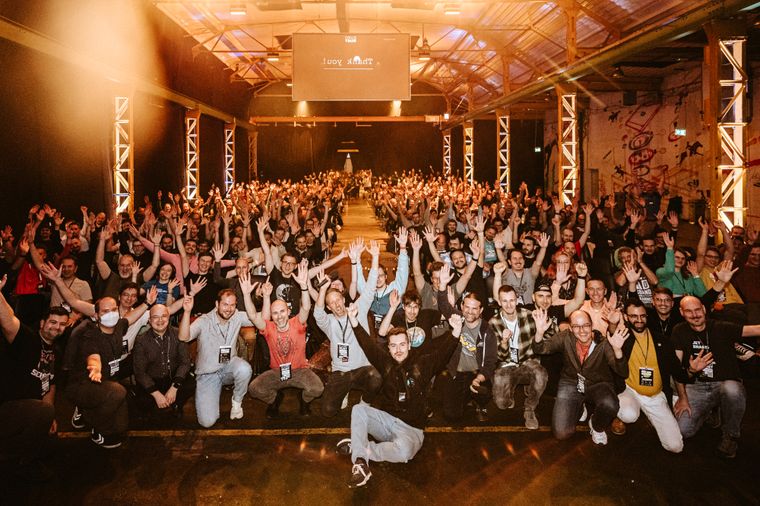 Photo of EuroRust 2024's speakers, organizers, moderators and the audience in the background, all with theirs hands in the air