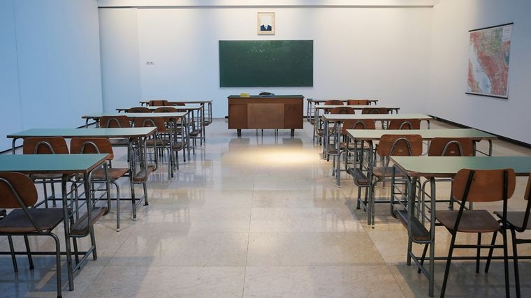 Photo of a classroom with benches facing a blackboard